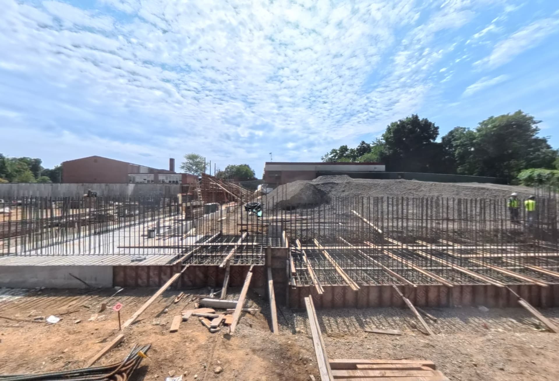 Reinforced steel rebar and wooden formwork prepared for concrete foundation pours at the Long Lots Elementary School site in September 2026